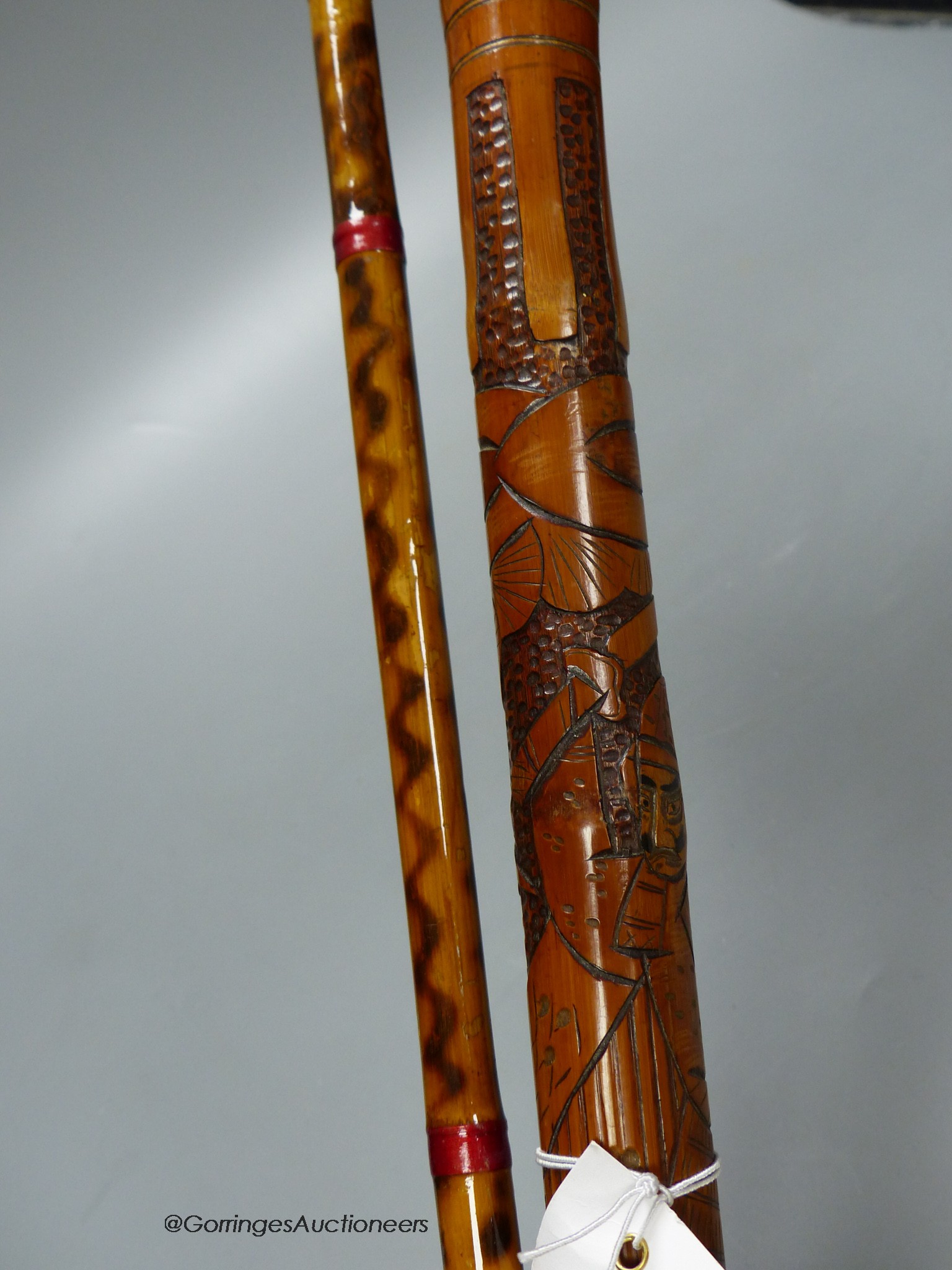 A Japanese carved bamboo walking stick and a Persian polychrome painted walking cane, tallest 97cm